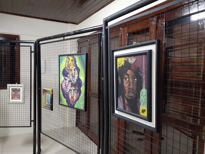 Foto da sala de convivência contendo exposição de quadros