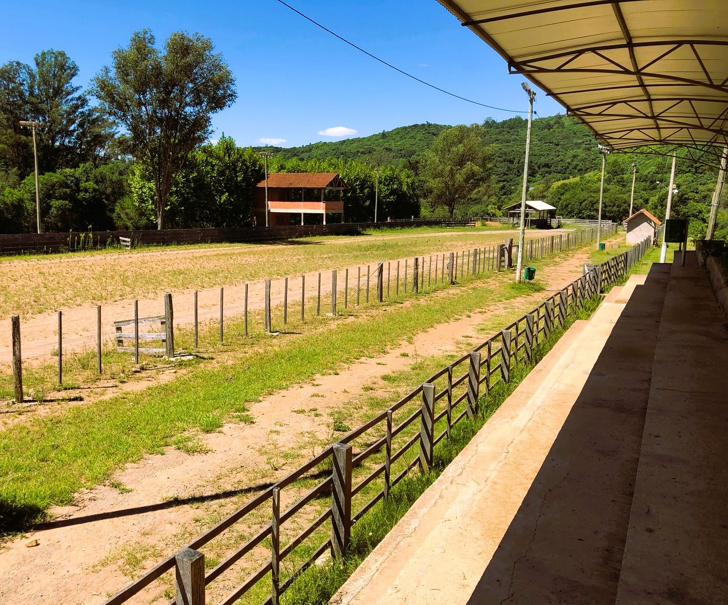 Cancha com cercado e árvores ao fundo